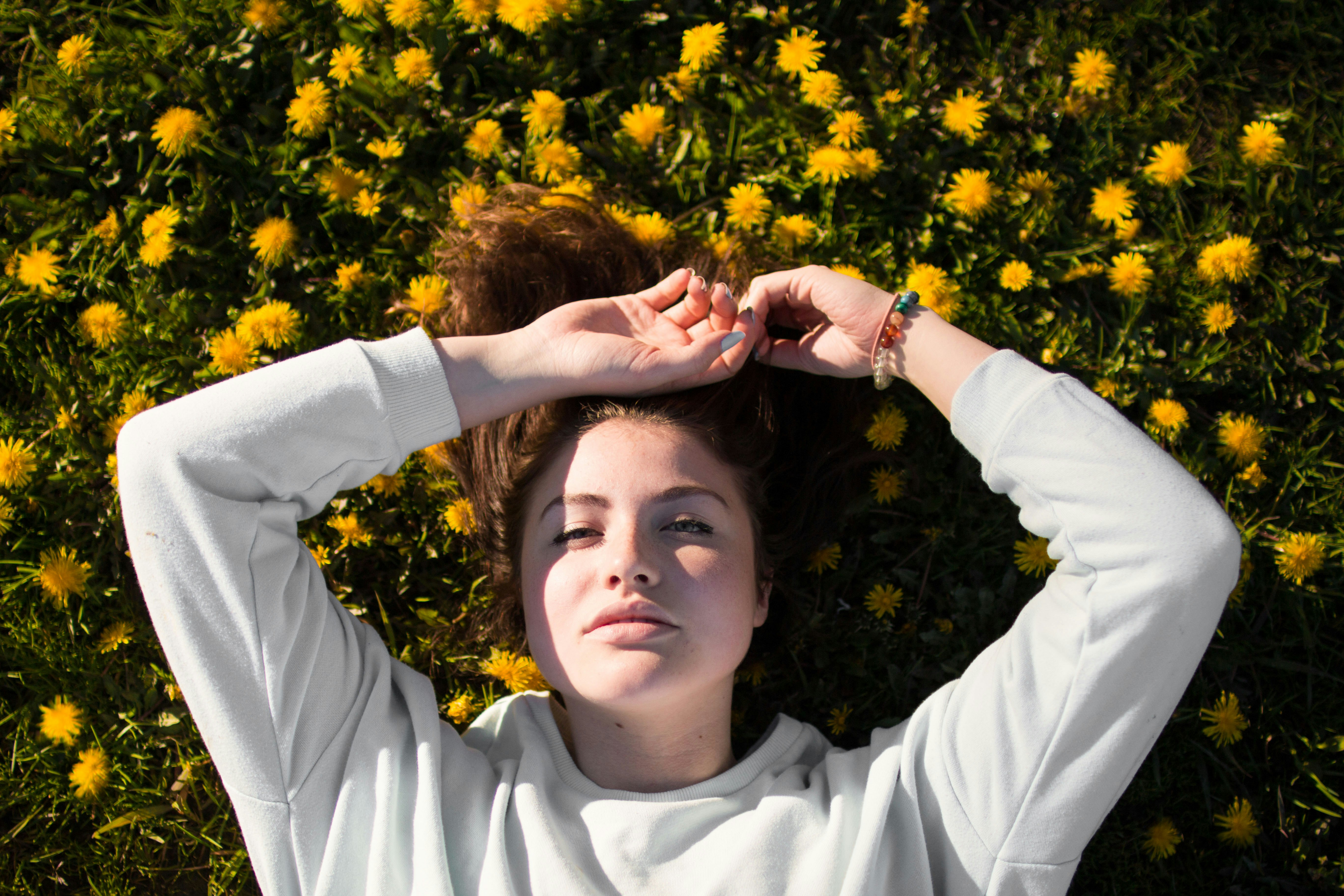 woman in white top laying on flowers